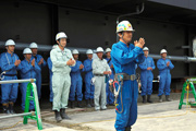 Crane operator Koji Nishitani leading the team in the ceremony offering prayers for safety.