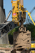 The drill shaft digs up the clay that is stuck on the drill. The forklift strips off the clay each time and the shaft repeats drilling.